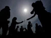 People gathering in front of the UMass Dartmouth observatory to view the partial solar eclipse that swept over the area, share the few sets of eclipse glasses on hand to see the event.   [ PETER PEREIRA/THE STANDARD-TIMES/SCMG ]